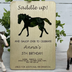 A party invitation made out of wood. The words Saddle up! appears at the top then there is a cutout of a cantering horse and then below that And Gallop Over To Celebrate with name and details below.