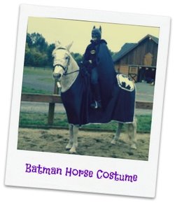 A horse dressed up as Batman being ridden by someone in a Batman costume.