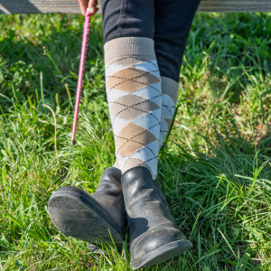 A pair of feet with boots and socks on with the socks showing.