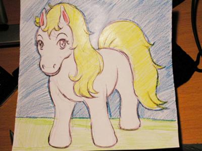 A drawing of a cartoon pony. The pony's body is pink and the mane and tail are yellow. There is green grass on the ground and a blue sky behind and above the pony.