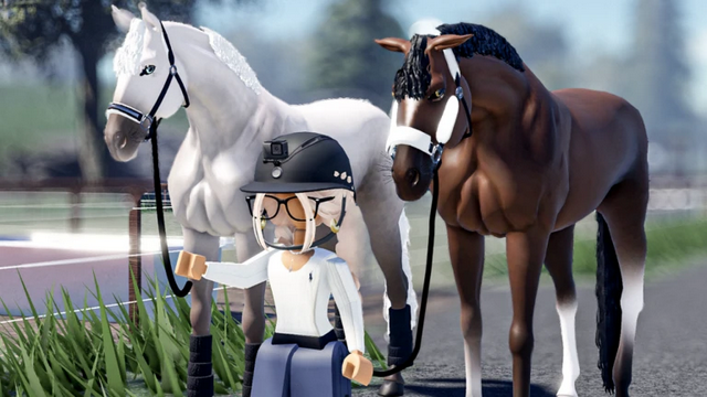 A Roblox-style character wearing a riding helmet and glasses holds the reins of two horses—one white and one brown with white markings—standing on a grassy area near a fenced riding arena.