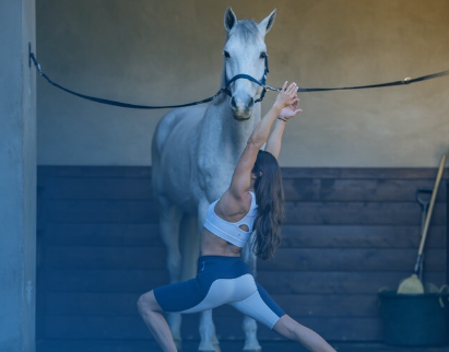 Image from Train With Shelby of a woman doing yoga in front of a horse