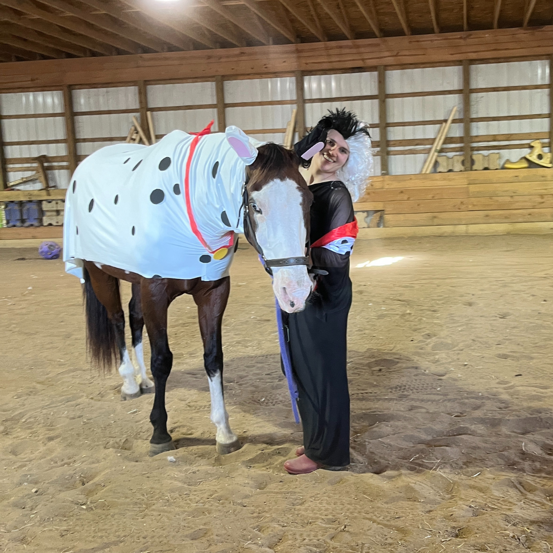 Cruella de vil horse costume with the horse dressed as a dalmatian and a woman dressed as cruella de vil